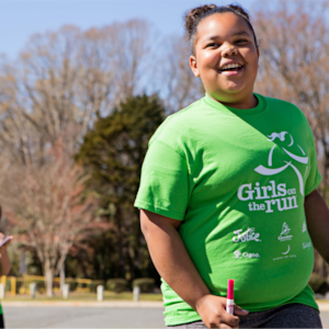 A Girls on the Run participant smiles while outside at program practice
